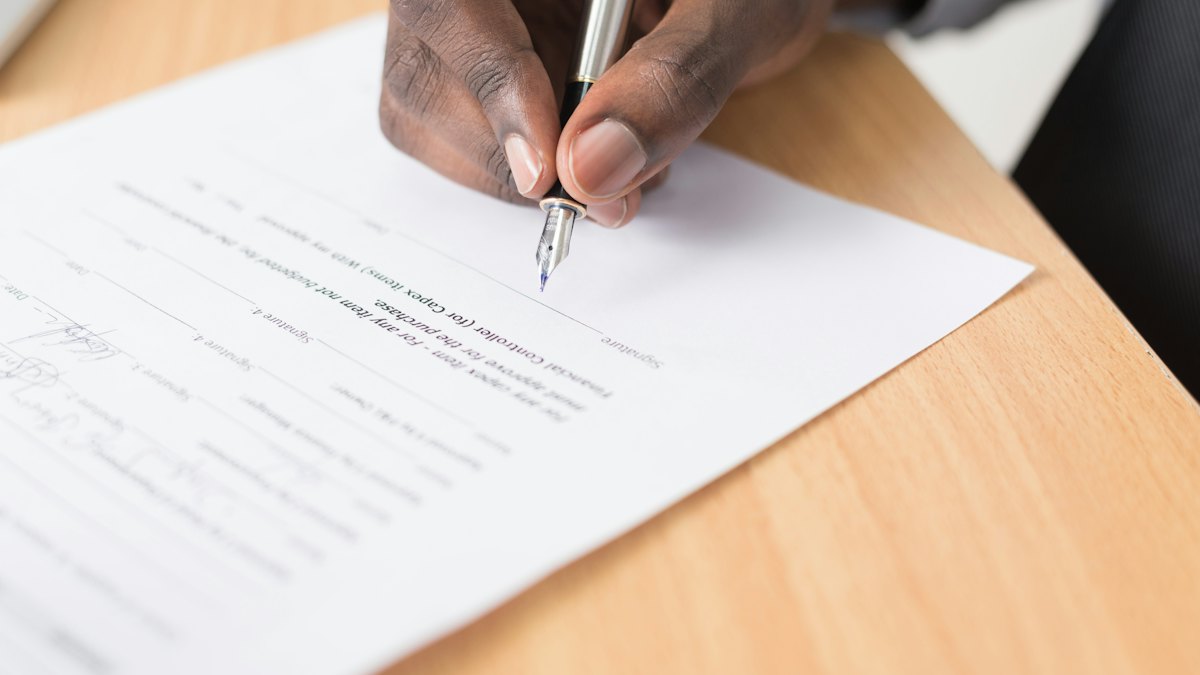 Hand signing a contract with a fountain pen