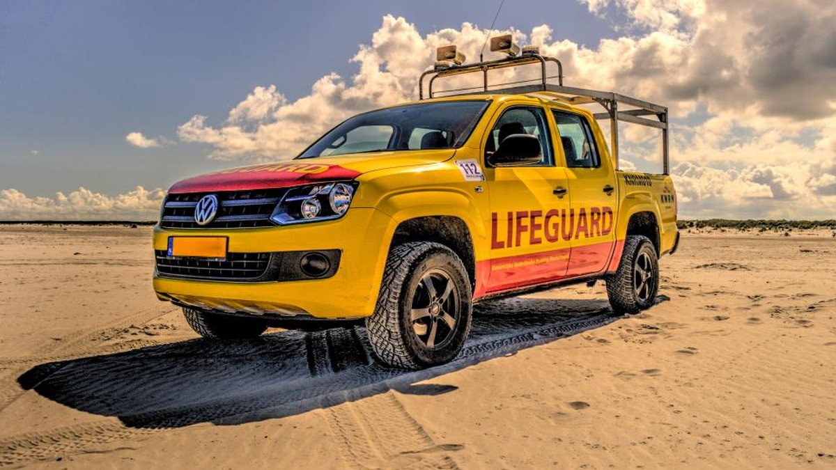 Yellow lifeguard truck parked on a beach