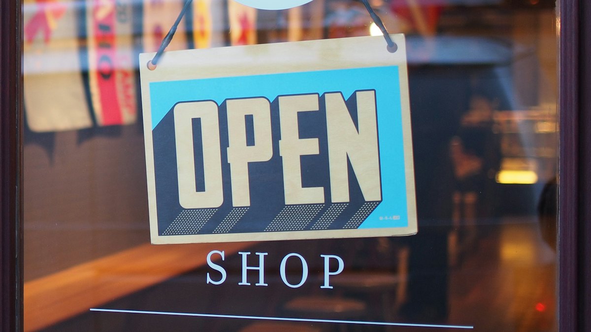 Illuminated OPEN sign hanging in a shop window